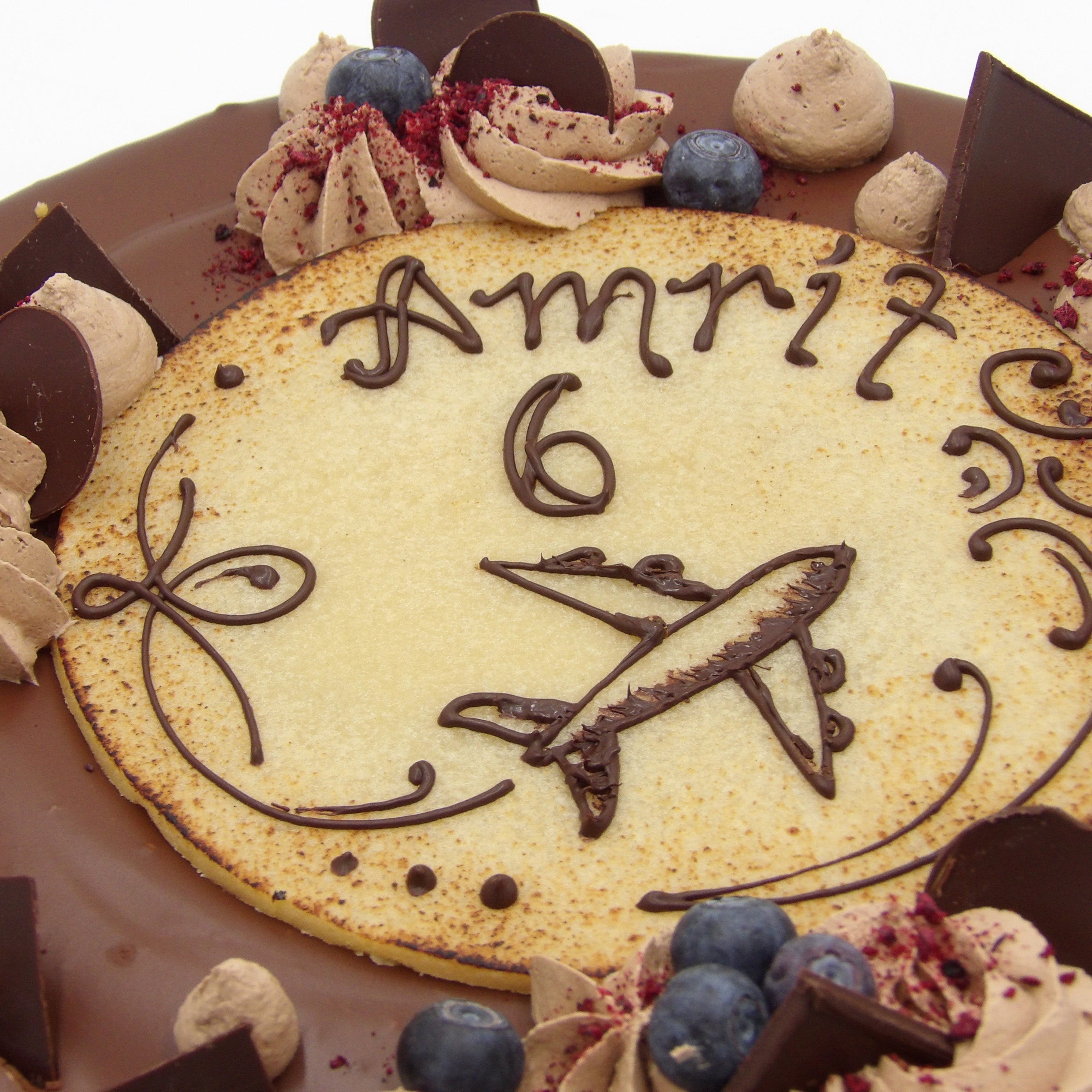 Nahaufnahme von einem beschriftetem Marzipanaufleger auf einer Nougattorte